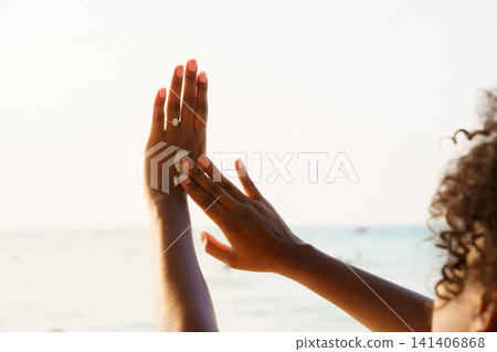 Black woman applying sunscreen on her hand at the beach Black woman applying sunscreen on her hand at the beach 141406868