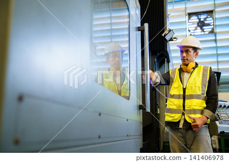 Professional technician wearing hard hat inspecting automated equipment 141406978