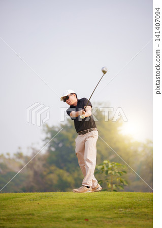 Asian male golfer hitting a powerful drive on green golf course Asian male golfer hitting a powerful drive on green golf course 141407094