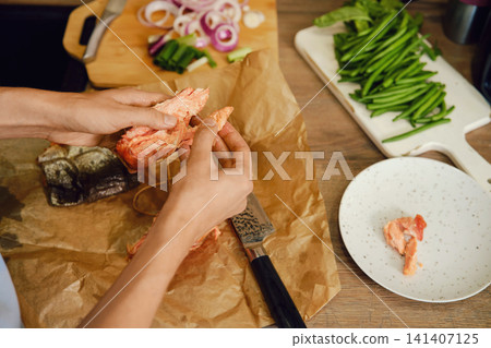 Top view of hands tearing hot smoked pink salmon into pieces Top view of hands tearing hot smoked pink salmon into pieces 141407125