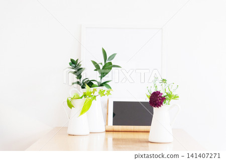 White walls and a wooden table adorned with green and purple flowers; a tablet device. White walls and a wooden table adorned with green and purple flowers; a tablet device. 141407271