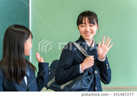 一群面帶笑容的中學生和高中女生在教室裡和朋友打招呼,準備上學。 一群面帶笑容的中學生和高中女生在教室裡和朋友打招呼,準備上學。 141407277