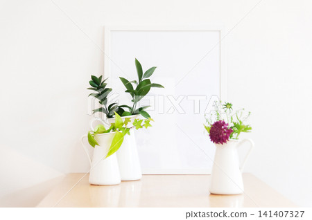 一瓶白色花瓶,裡面插著盆栽和紫色花朵。 一瓶白色花瓶,裡面插著盆栽和紫色花朵。 141407327