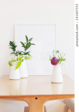 房間裡擺放著簡單的綠色植物和一張明亮的餐桌。 房間裡擺放著簡單的綠色植物和一張明亮的餐桌。 141407355
