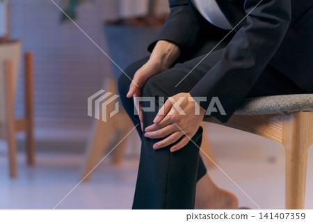 Close-up of a woman in a suit with a leg injury. 141407359