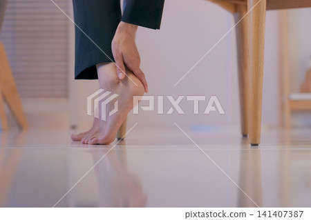 特寫鏡頭：一位身穿西裝的女子摀著腿。 141407387
