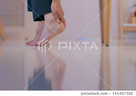特寫鏡頭:一位身穿西裝的女子摀著腿。 特寫鏡頭:一位身穿西裝的女子摀著腿。 141407388