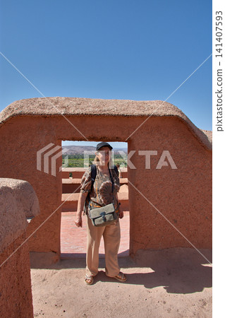 A senior tourist smiles as she poses under an adobe frame at the Taourirt Kasbah in Ouarzazate, Morocco. A senior tourist smiles as she poses under an adobe frame at the Taourirt Kasbah in Ouarzazate, Morocco. 141407593
