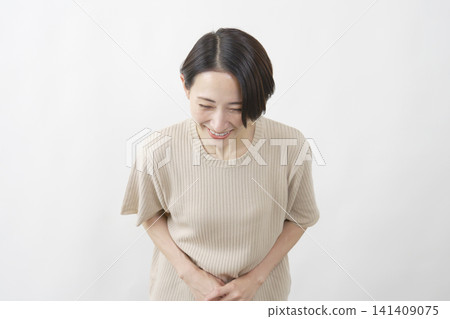 A middle-aged woman smiles and bows; white background. 141409075