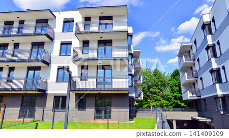 European residential architecture harmonizing with nature. Eco-friendly living in city with greens. Eco apartment building saving energy and fresh air concept. European residential architecture harmonizing with nature. Eco-friendly living in city with greens. Eco apartment building saving energy and fresh air concept. 141409109