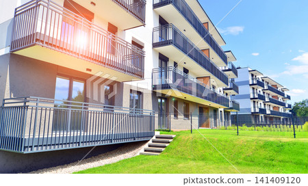 European residential architecture harmonizing with nature. Eco-friendly living in city with greens. Eco apartment building saving energy and fresh air concept. European residential architecture harmonizing with nature. Eco-friendly living in city with greens. Eco apartment building saving energy and fresh air concept. 141409120
