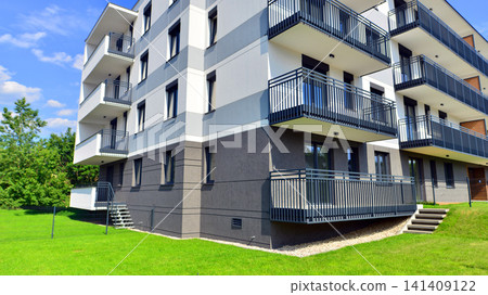 European residential architecture harmonizing with nature. Eco-friendly living in city with greens. Eco apartment building saving energy and fresh air concept. European residential architecture harmonizing with nature. Eco-friendly living in city with greens. Eco apartment building saving energy and fresh air concept. 141409122