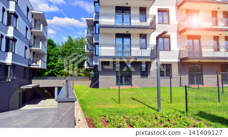 European residential architecture harmonizing with nature. Eco-friendly living in city with greens. Eco apartment building saving energy and fresh air concept. European residential architecture harmonizing with nature. Eco-friendly living in city with greens. Eco apartment building saving energy and fresh air concept. 141409127
