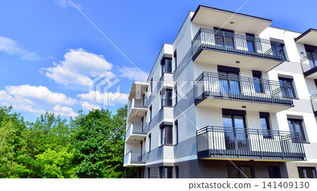 European residential architecture harmonizing with nature. Eco-friendly living in city with greens. Eco apartment building saving energy and fresh air concept. European residential architecture harmonizing with nature. Eco-friendly living in city with greens. Eco apartment building saving energy and fresh air concept. 141409130