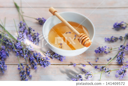 Honey in bowl with lavender flowers and dipper Honey in bowl with lavender flowers and dipper 141409572
