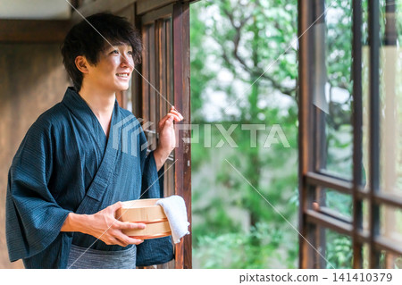 A man wearing a yukata staying at a hot spring, a hot spring inn, or a public bath A man wearing a yukata staying at a hot spring, a hot spring inn, or a public bath 141410379