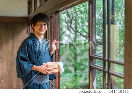 A man wearing a yukata staying at a hot spring, a hot spring inn, or a public bath A man wearing a yukata staying at a hot spring, a hot spring inn, or a public bath 141410381