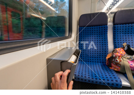 Small trash bin mounted between seats inside German S-Bahn train carriage Small trash bin mounted between seats inside German S-Bahn train carriage 141410388