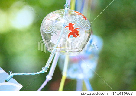 Glass wind chimes swaying in the gentle breeze Glass wind chimes swaying in the gentle breeze 141410668