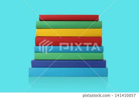 Books are arranged in a stack on a blue surface 141410857