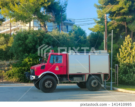 Mercedes Benz Unimog red fire truck parked on rural road Mercedes Benz Unimog red fire truck parked on rural road 141410995