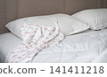 Floral nightdress on white bed in cozy modern bedroom 141411218