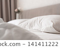 White pillow on bed with soft bedding in cozy bedroom 141411222