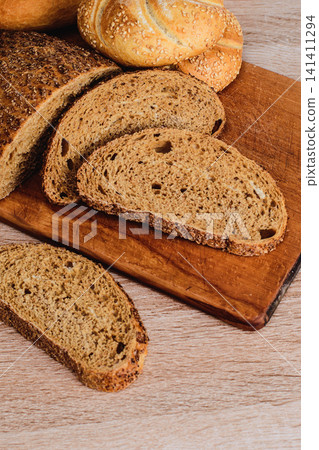 French baguettes. Fresh crispbread. Bread background. Different breed on wooden background. French baguettes. Fresh crispbread. Bread background. Different breed on wooden background. 141411294