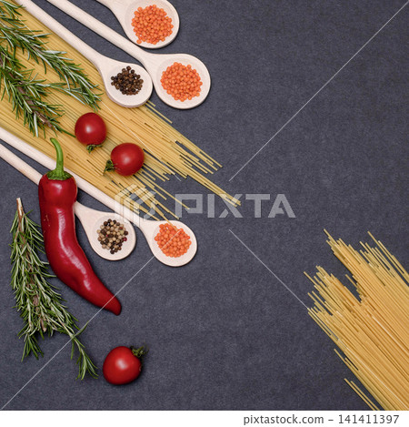 Italian food ingredients.Still life of cooking pasta on a black background top view. Wooden spoons with spices. Frame of products and vegetables. Italian food ingredients.Still life of cooking pasta on a black background top view. Wooden spoons with spices. Frame of products and vegetables. 141411397