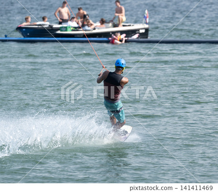 Cable Wakeboarder Riding on Lake in Summer. Cable Wakeboarder Riding on Lake in Summer. 141411469