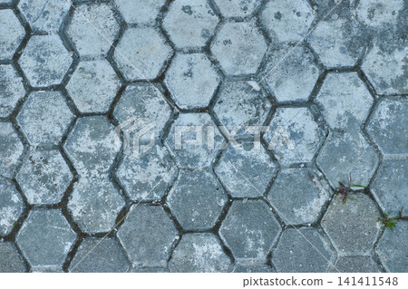 Grey hexagonal paving tiles. Textured concrete pavement blocks. Old stone hexagon walkway background. 141411548