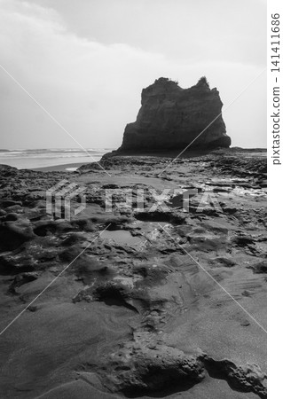Aerial view of coastal rock formations rising from the sea with crashing waves and sandy beach in Indonesia Aerial view of coastal rock formations rising from the sea with crashing waves and sandy beach in Indonesia 141411686