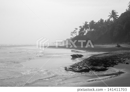 Aerial view of coastal rock formations rising from the sea with crashing waves and sandy beach in Indonesia Aerial view of coastal rock formations rising from the sea with crashing waves and sandy beach in Indonesia 141411703