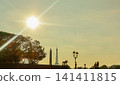 Paris skyline silhouetted by bright sun, featuring Eiffel Tower and Luxor Obelisk at famous landmark 141411815