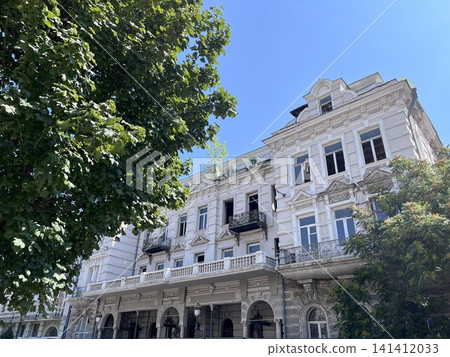 Old building under blue sky in city with trees nearby captures historical architecture Old building under blue sky in city with trees nearby captures historical architecture 141412033