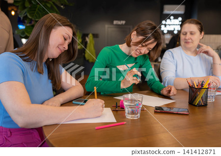 Colleagues experimenting with colors and planning ideas at bright coffee shop table. Planning, colors, coffee shop, ideas, colleagues. Colleagues experimenting with colors and planning ideas at bright coffee shop table. Planning, colors, coffee shop, ideas, colleagues. 141412871