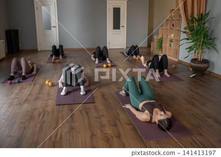 Women three generations doing different yoga exercises lying on back. Women's health of joints and spine Women three generations doing different yoga exercises lying on back. Women's health of joints and spine 141413197