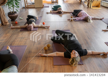 Women three generations doing different yoga exercises lying on back. Women's health of joints and spine Women three generations doing different yoga exercises lying on back. Women's health of joints and spine 141413204