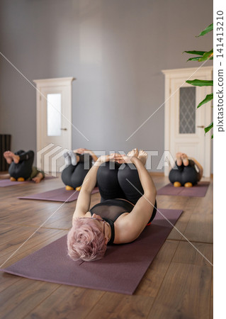 Woman, instructor and yoga class for fitness, stretching or back at wellness retreat. Yogi, group exercise and people with trainer at resort for balance, healing and health with side bend outdoor Woman, instructor and yoga class for fitness, stretching or back at wellness retreat. Yogi, group exercise and people with trainer at resort for balance, healing and health with side bend outdoor 141413210
