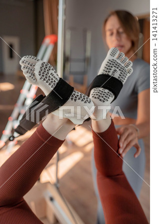 A detailed closeup of a foot work and core exercise on a Balanced Body Reformer machine illuminated by sunlight A detailed closeup of a foot work and core exercise on a Balanced Body Reformer machine illuminated by sunlight 141413271