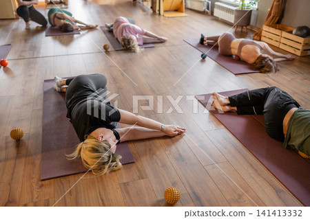 Woman instructor teaching mobility to a group of seniors in a pilates studio. Group of senior people exercising on mats to improve balance and flexibility. Healthy lifestyle and wellness Woman instructor teaching mobility to a group of seniors in a pilates studio. Group of senior people exercising on mats to improve balance and flexibility. Healthy lifestyle and wellness 141413332