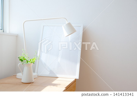 A desk lamp and a small potted plant placed on a desk where natural light shines in. A desk lamp and a small potted plant placed on a desk where natural light shines in. 141413341