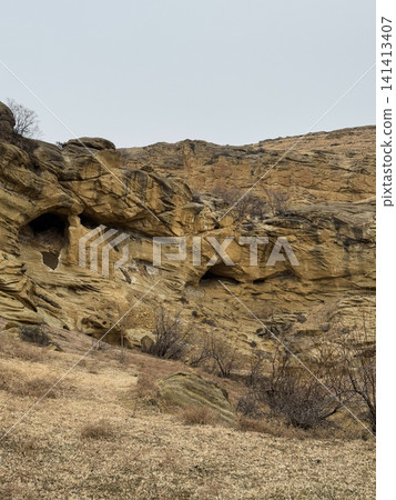 Close-up of sandstone formations and natural caves on rocky hillside. Close-up of sandstone formations and natural caves on rocky hillside. 141413407