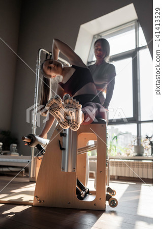Woman doing mermaid exercise in a sunlite, modern pilates studio, embodying calm, focus, and strength Woman doing mermaid exercise in a sunlite, modern pilates studio, embodying calm, focus, and strength 141413529
