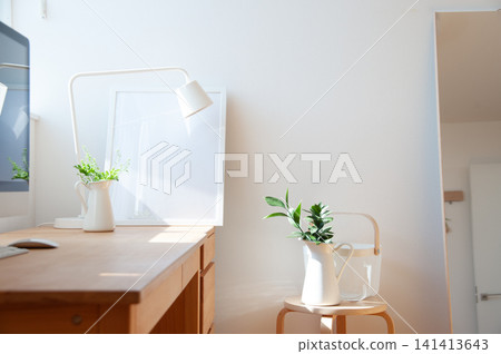 A bright room with a wooden desk and houseplants. A bright room with a wooden desk and houseplants. 141413643