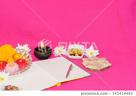 Diwali chopda pujan concept with open notebook sweets and diya Diwali chopda pujan concept with open notebook sweets and diya 141414483