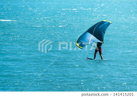 Person wing foiling on Lake Wolfgangsee in Austria, illustrating a modern summer water sports lifestyle with dynamic energy. 141415201