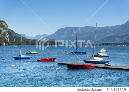 Sailboats on Lake Wolfgangsee in the Salzkammergut, illustrating scenic lake tourism in Austria and classic alpine summer vibe. Sailboats on Lake Wolfgangsee in the Salzkammergut, illustrating scenic lake tourism in Austria and classic alpine summer vibe. 141415519