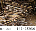 A pile of dry natural firewood, branches, and broken bamboo sticks stacked on the ground. Concept for biomass energy, rustic rural lifestyle, agriculture, and fuel material for campfires 141415930