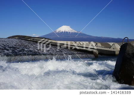 With Mount Fuji standing out against the blue sky in the background, a scene of water spraying in front of the dam. January, Mount Fuji 2138, Fujikawa Dam and water spray. With Mount Fuji standing out against the blue sky in the background, a scene of water spraying in front of the dam. January, Mount Fuji 2138, Fujikawa Dam and water spray. 141416389